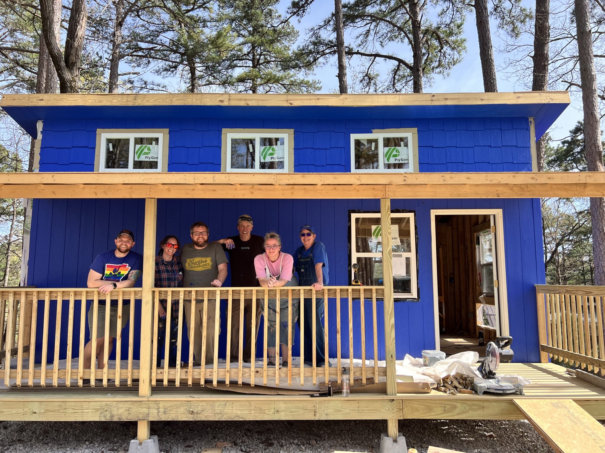 home under contruction with group photo in front center